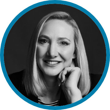 A woman with straight shoulder length blonde hair, Joanne Henry, Founder of Lakeshore Media Services, is pictured smiling in a round black and white photograph.